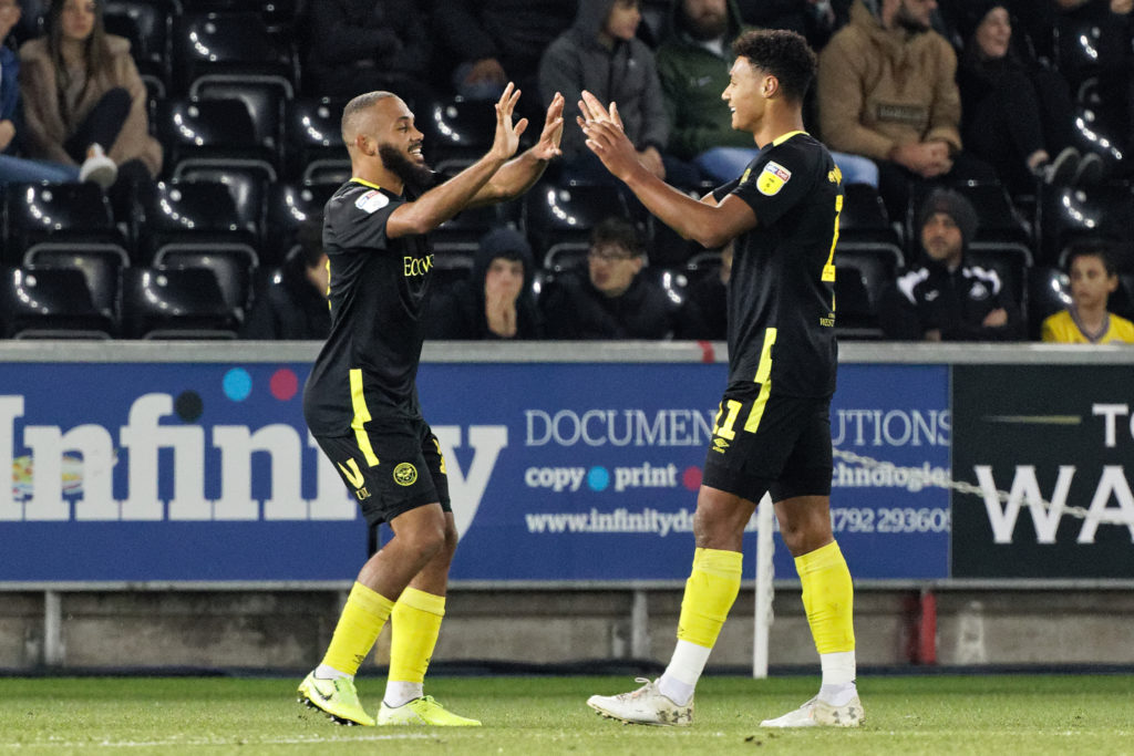 Bryan Mbeumo and Ollie Watkins of Brentford celebrate their second goal which wasd an own goal by Jake Bidwell of Swansea City during the Sky Bet Championship match between Swansea City and Brentford at the Liberty Stadium on October 22, 2019