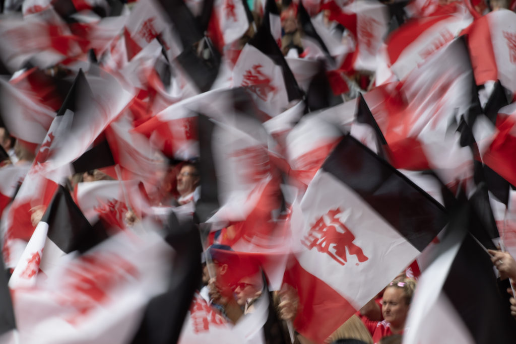 Manchester United fans wave flags with Red Devil logo