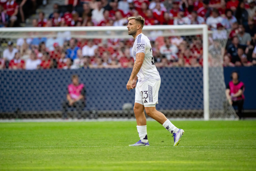 Luke Shaw in action for Manchester United in white away kit.