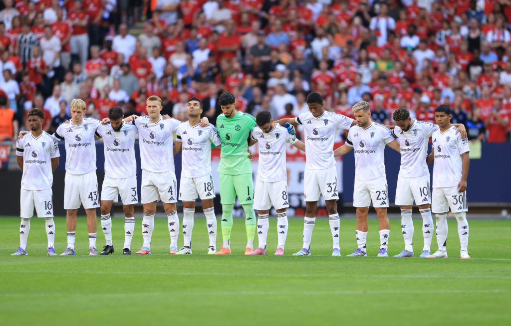 Manchester United squad stand for minutes silence.