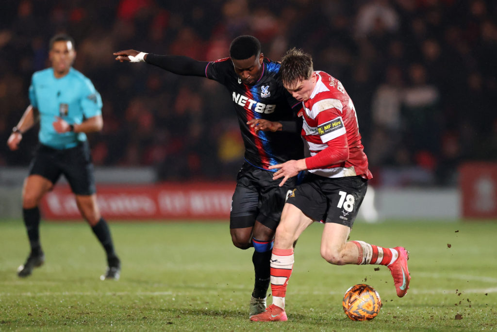 Marc Guehi of Crystal Palace battles for the ball with Ethan Ennis of Doncaster Rovers during the Emirates FA Cup Fourth Round match between Doncaster Rovers and Crystal Palace at Eco-Power Stadium on February 10, 2025