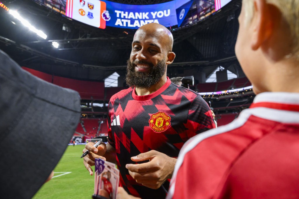 Manchester United summer signing Bryan Mbeumo signs an autograph after a match against Everton at the Mercedes-Benz Stadium in 2025 in Atlanta, Georgia.