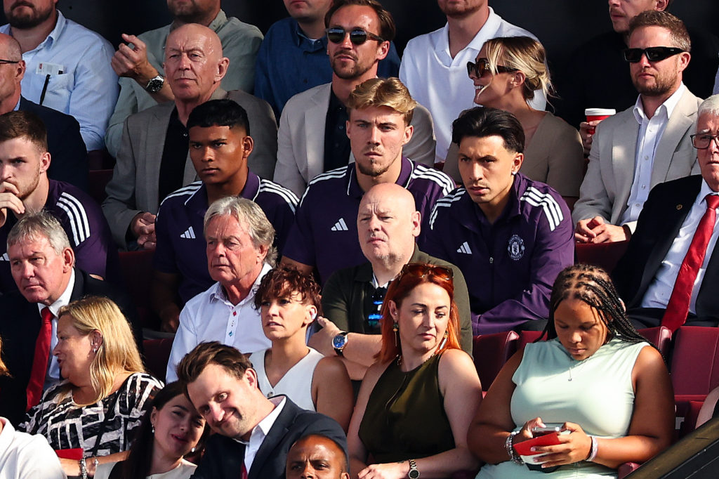 Rasmus Hojlund of Manchester United sits in the stands with Diego León and Lisandro Martínez during the Premier League match between Manchester United and Arsenal at Old Trafford on August 17, 2025