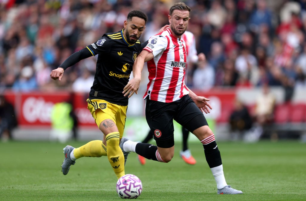 Matheus Cunha and Jordan Henderson competing for a ball