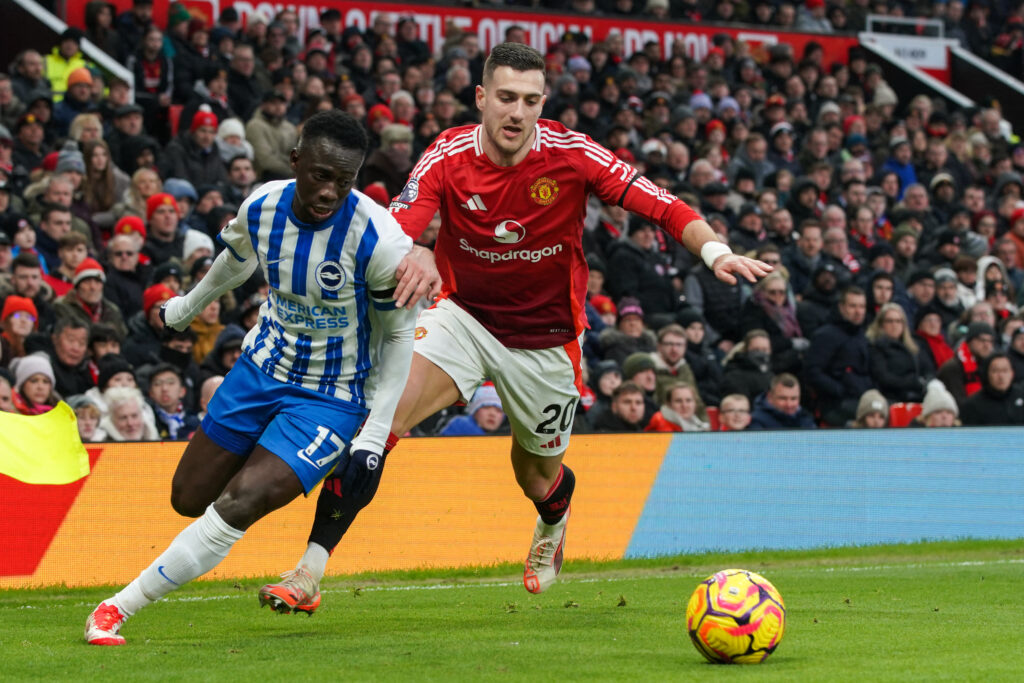 Yankuba Minteh competing with Diogo Dalot for the ball
