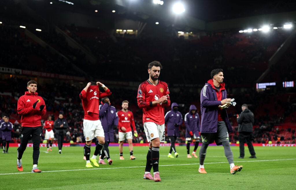 Manchester United players applaud fans.