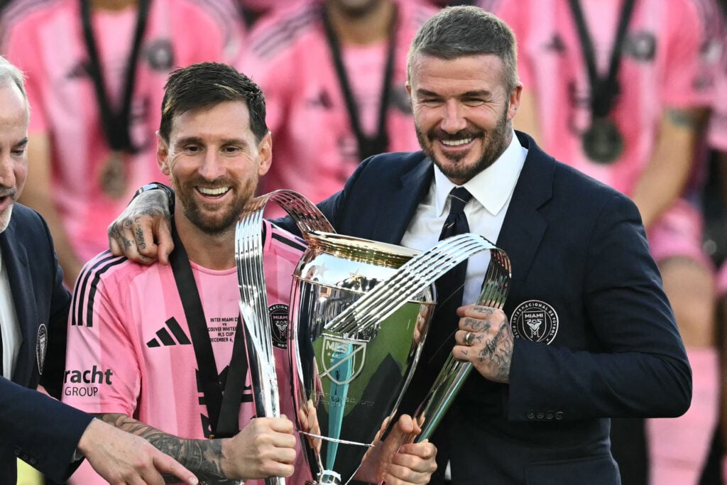 Inter Miami's Argentine forward #10 Lionel Messi (L) poses with the trophy next to the team's owner David Beckham (R) after winning the Major League Soccer (MLS) Cup final between Inter Miami and the Vancouver Whitecaps at Chase Stadium in Fort Lauderdale, Florida, on December 6, 2025.