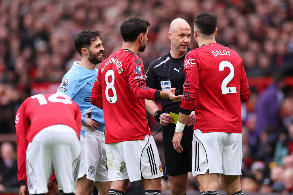 Anthony Taylor gives Diogo Dalot a yellow card