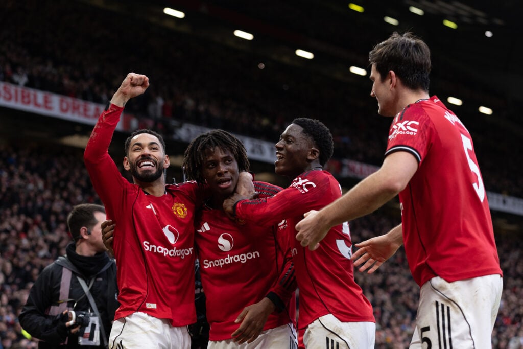 Patrick Dorgu celebrates with teammates Matheus Cunha and Kobbie Mainoo during the Premier League match between Manchester United and Manchester City at Old Trafford in 2026 in Manchester, England.