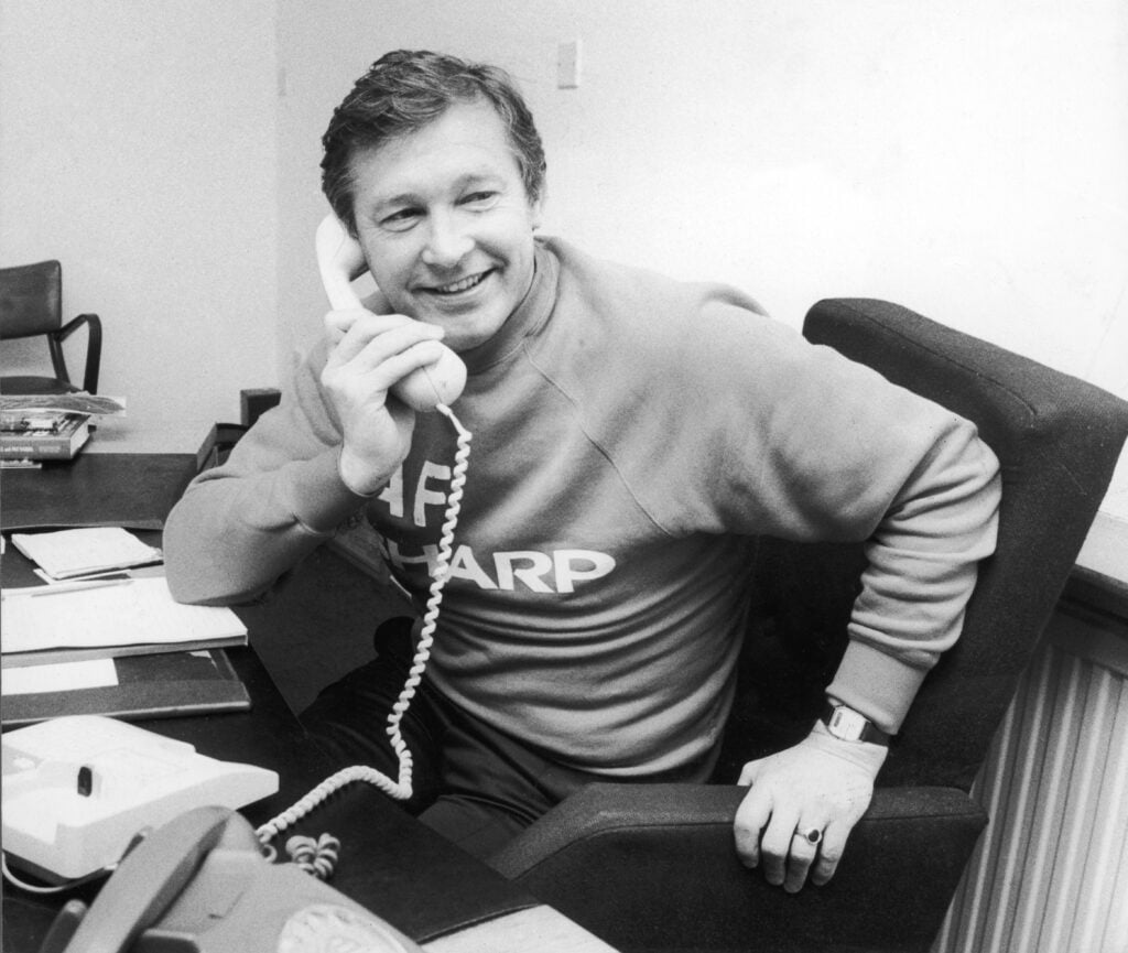 Manchester United manager Alex Ferguson speaking on the telephone in his office, November 1986.