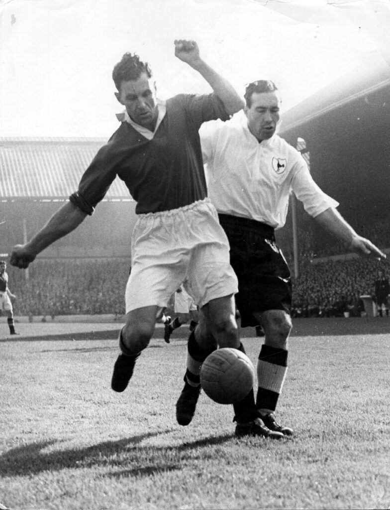 Jack Rowley dribbles the ball away from Alf Ramsey