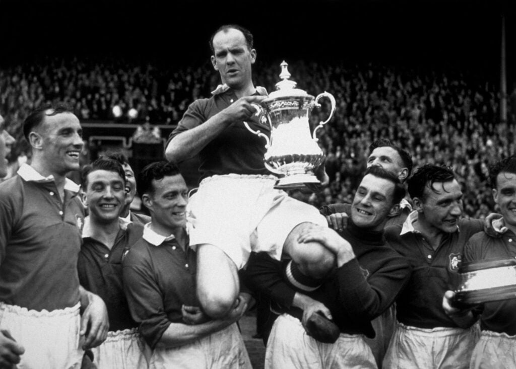 Manchester United captain Johnny Carey is carried shoulder high after his team beat Blackpool 4-2 in the FA Cup final